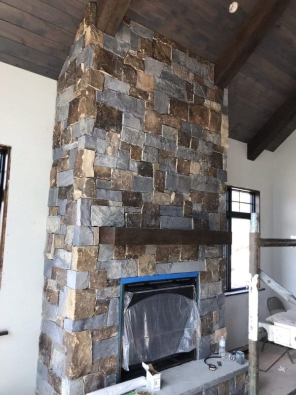 drystacked mortarless fireplace with earthy brown and grey real stone veneer