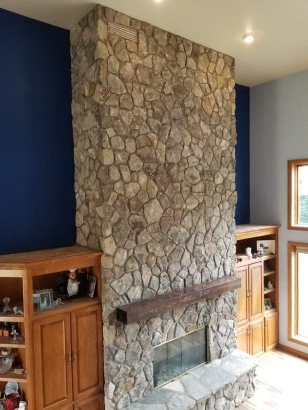 Side View of Living Room Fireplace Covered with Moss Rock Real Thin Stone Veneer
