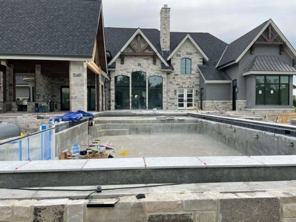 Backyard pool installation with Graphite real stone veneer